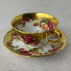 Three-quarter view of Royal Chelsea Golden Roses teacup and matching saucer
