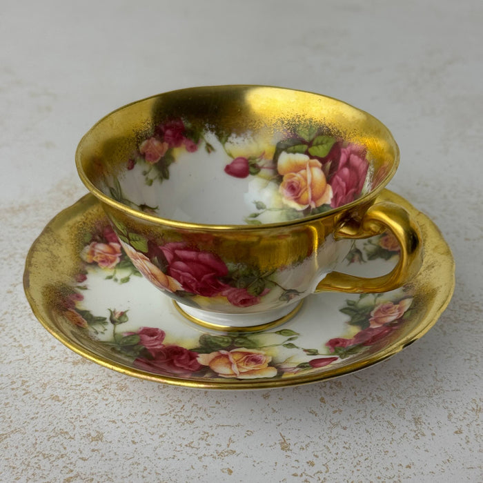 Three-quarter view of Royal Chelsea Golden Roses teacup and matching saucer