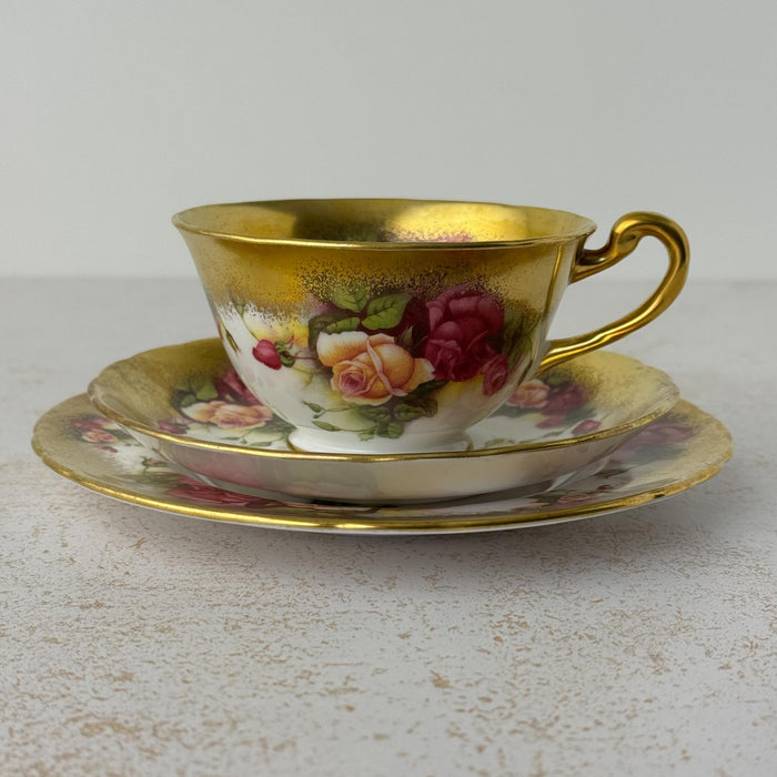 Side view of Royal Chelsea Golden Roses teacup stacked on matching saucer and side plate