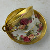 Back view of Royal Chelsea Golden Roses teacup resting on its side on matching saucer