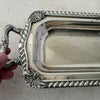 Close up of vintage silverplate rectangular serving tray with hand touching handle
