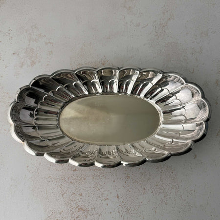Top down view of vintage Towle silverplate oval bread tray with scalloped rim
