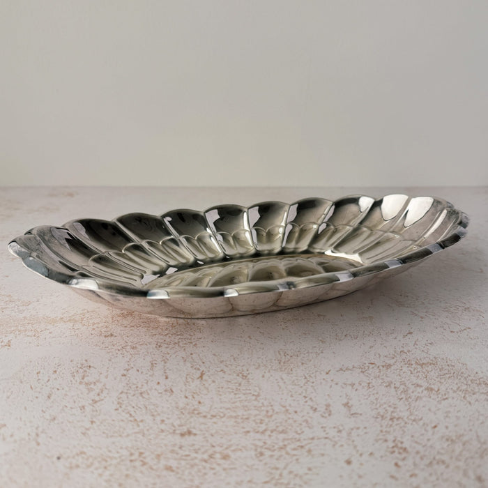 Angled side view of vintage Towle silverplate oval bread tray with scalloped rim