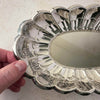 Close-up view of vintage Towle silverplate oval bread tray with fingers holding the scalloped rim