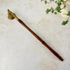 Full view of vintage brass candle snuffer showing long wooden handle, brass hardware, and classic design