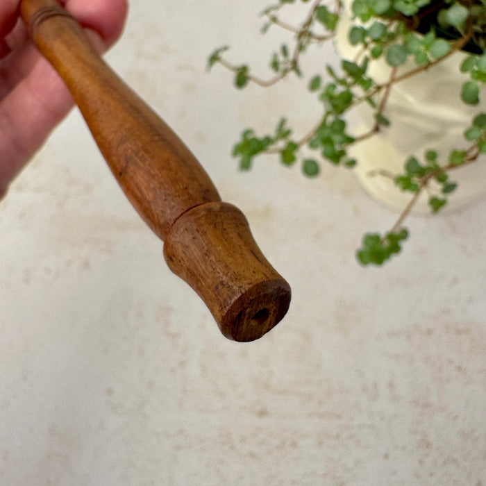 End view of brass candle snuffer's turned wood handle