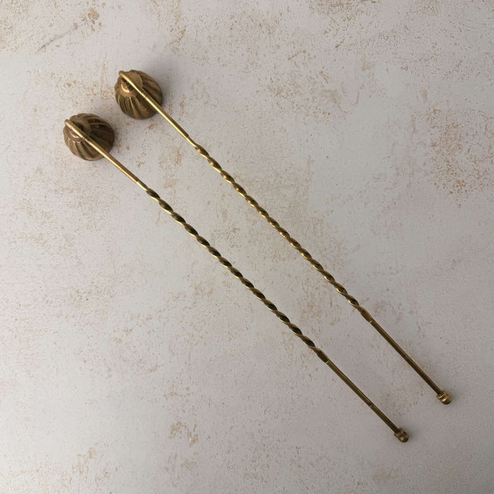 Top down view of pair of vintage brass candle snuffers with twisted handles