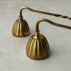 Close-up view of vintage brass candle snuffers with twisted handles