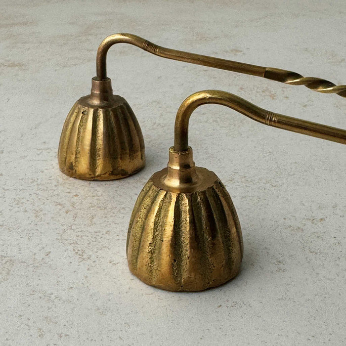 Close-up view of vintage brass candle snuffers with twisted handles