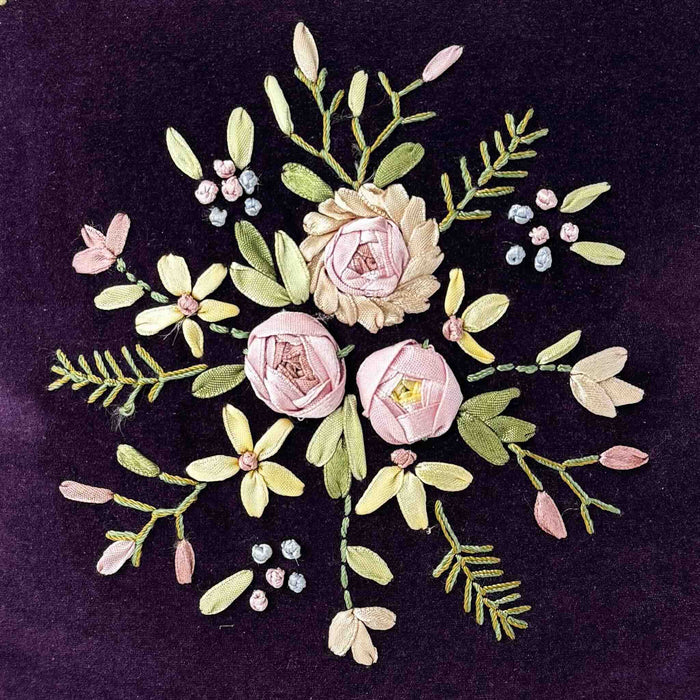 Close-up of center ribbon applique and embroidery on purple velvet floral ribbon accent pillow