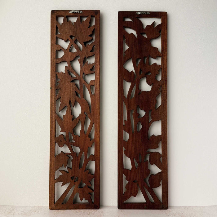 Back view of vintage hand-carved wooden panels with birds and flowers