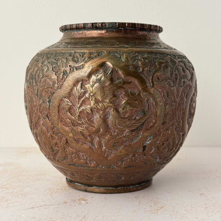 Front view of vintage rustic hand decorated copper vessel