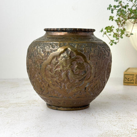 Vintage copper vase with rounded form, narrow opening, aged patina, and hand-decorated bird and floral motifs styled with trailing plant