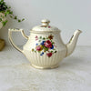 Opposite side of vintage Sadler teapot with pink rose floral bouquet, ribbed cream body, long spout, and gold-trimmed handle.