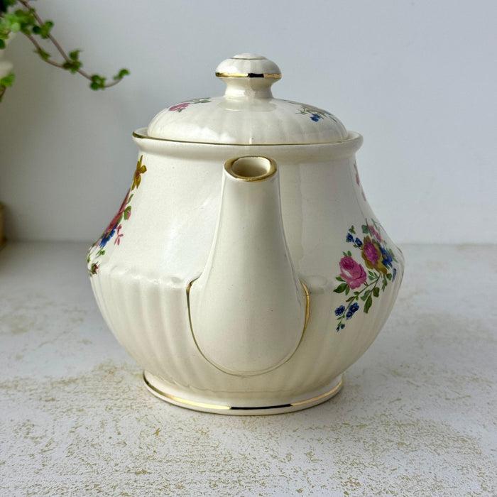 Spout view of vintage Sadler floral teapot showing smaller flower sprays and gold trim around the spout and base.