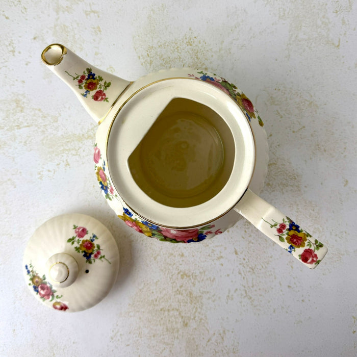 Overhead view of open vintage Sadler teapot with the floral lid removed beside it, showing the clean cream-colored interior.