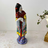 Side view of vintage Chinese porcelain woman figurine showing teal and yellow geometric robe panels and cobalt blue base with floral scrollwork