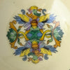 Close-up of the bowl's central decoration showing two stylized birds, yellow and blue wings, green foliage, lavender flowers, and gold-colored scrolling ornament.