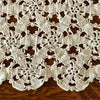 Close-up of the crochet runner showing repeating floral rosettes, open spaces, small looped details, and scalloped outer edge.