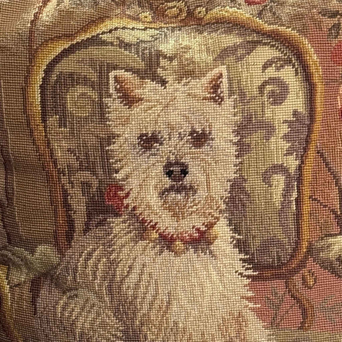 Close view of the needlepoint scene showing the white Westie wearing a red collar and seated on a patterned armchair.