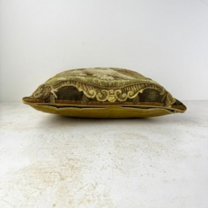 Lower edge of the pillow showing the needlepoint front, velvet backing, piping, and hidden zipper closure.