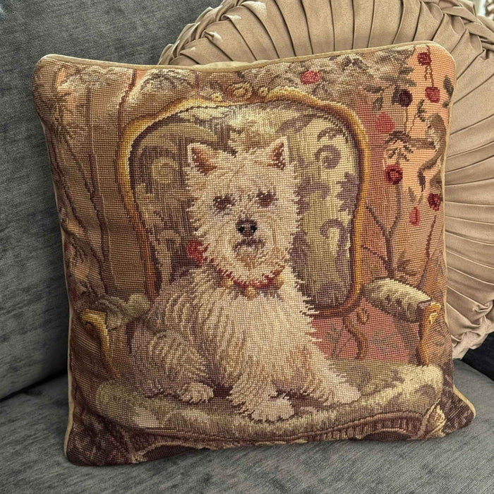 Vintage Westie needlepoint pillow styled on a chair with a round pleated cushion behind it.