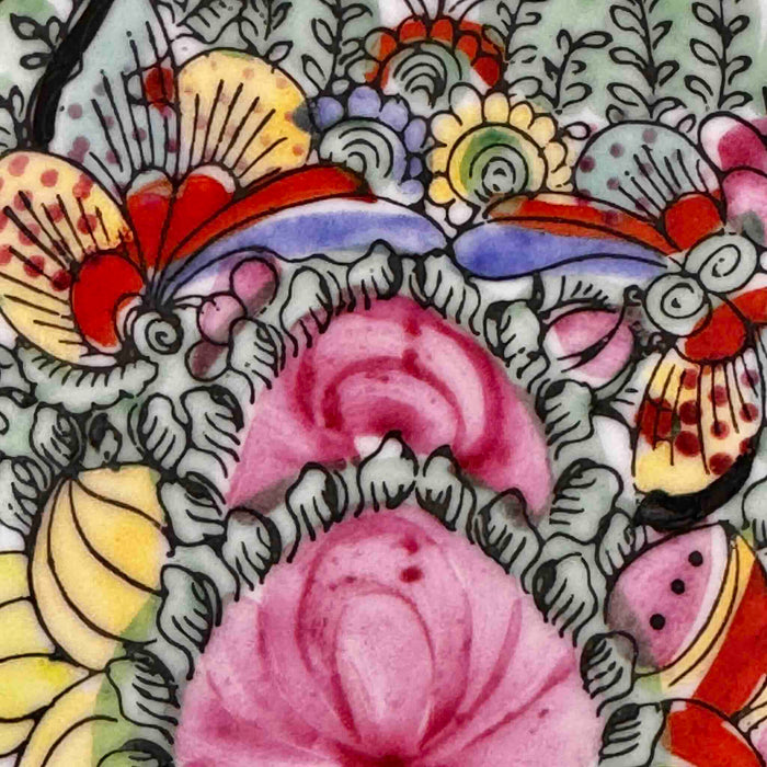 Close-up of cenral decoration of vintage Chinese-style export porcelain plate in pink, turquoise green, yellow, blue and iron red
