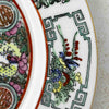 Close-up of border decoration of vintage Chinese-style export porcelain plate in pink, turquoise green, yellow, blue and iron red