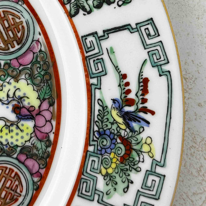 Close-up of border decoration of vintage Chinese-style export porcelain plate in pink, turquoise green, yellow, blue and iron red