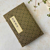 Vintage Chinese calligraphy presentation box, showing the phrase "Four Treasures of the Scholar's Studio" in brushed calligraphy on cream paper with gold border