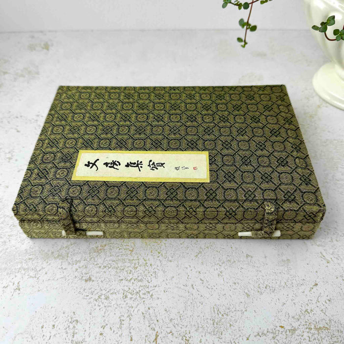 Top down view of closure side of vintage Chinese calligraphy presentation box on a light surface
