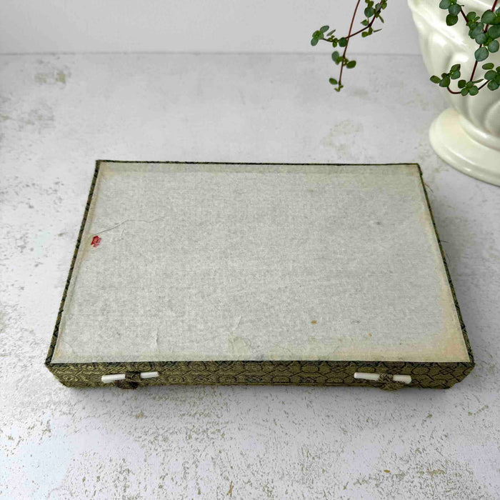 Top down view of paper underside of vintage Chinese calligraphy presentation box on a light surface