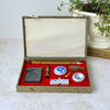 Open vintage Chinese calligraphy set in a fitted textile-covered box with red lining, brushes, inkstone, ink stick, seal and porcelain tools styled with a trailing plant and book