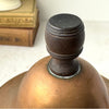 Close-up of the dark turned finial on the domed lid of the vintage copper kettle.