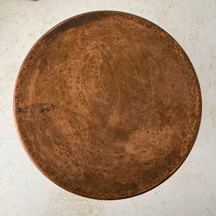 Bottom of vintage copper kettle showing the aged, naturally mottled copper surface.