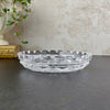 Side profile of the glass dish showing its low, shallow form, raised patterned sides, and evenly spaced notches around the rim.
