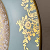 Close-up of ornate gold flowers, foliage and basket motifs on the turquoise blue porcelain rim.