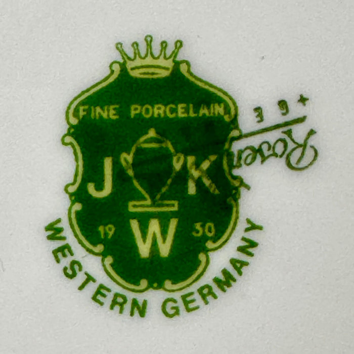Close-up of the green JKW Fine Porcelain Western Germany shield mark partially covering a Rosenthal mark.