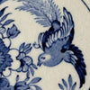 Close-up of blue flying bird and floral transfer decoration with visible crazing in the white glaze.