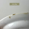 Close-up of shallow rim chip on one plate with visible crazing and small age-related marks.
