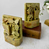 Vintage soapstone bookend with pierced floral carving displayed beside antique books with decorative bindings
