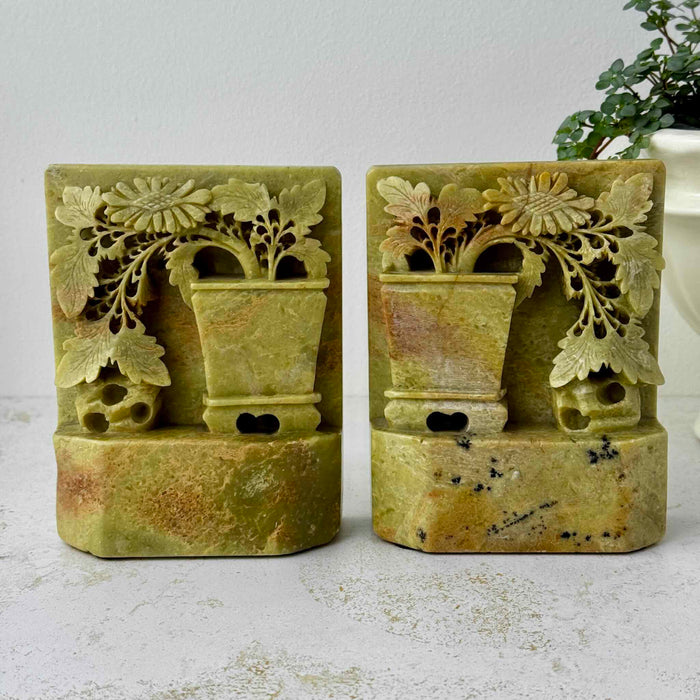 Front view of matching carved soapstone bookends featuring floral openwork and planter motifs