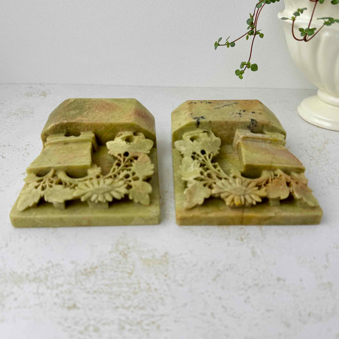 Top view of carved soapstone bookends highlighting pierced floral carving and dimensional openwork