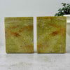 Back view of matching golden olive soapstone bookends showing natural stone variation and veining