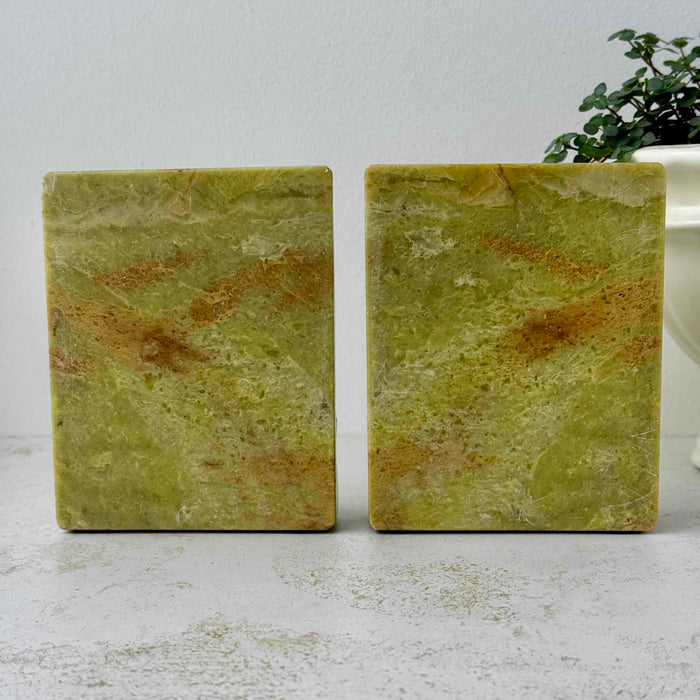 Back view of matching golden olive soapstone bookends showing natural stone variation and veining