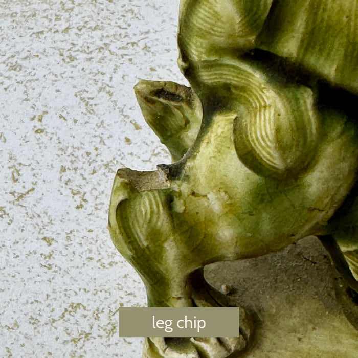 Close-up of one foo dog showing a chip to the rear leg area with visible age-related wear