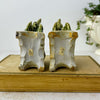 Underside view of both vintage foo dog figures showing unglazed bases and old inventory labels