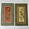 Pair of vintage Chinese embroidered textile wall panels with bird and floral motifs on rust and pale gold backgrounds, bordered with patterned green fabric
