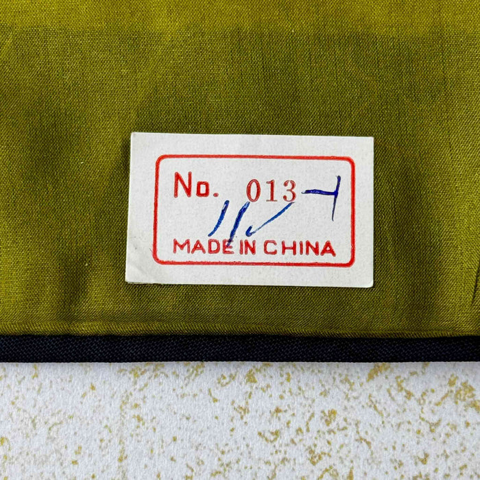 Close-up of original “Made in China” label attached to back of vintage embroidered textile wall panel