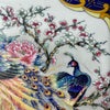 Detail view of the front panel showing colorful peacocks, peonies, and flowering branches on a vintage ceramic lamp